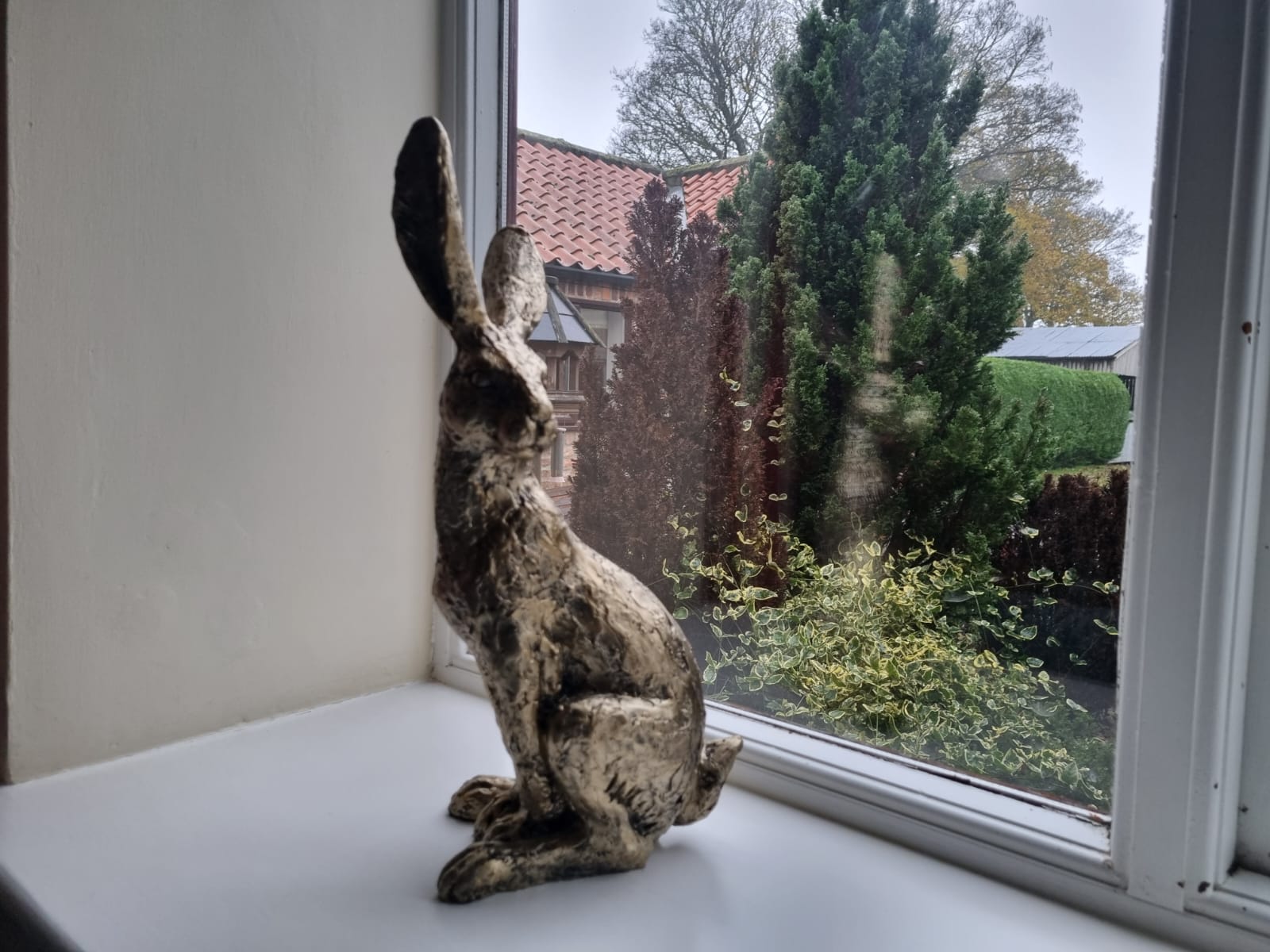 statue of a hare in front of the window of Granary cottage