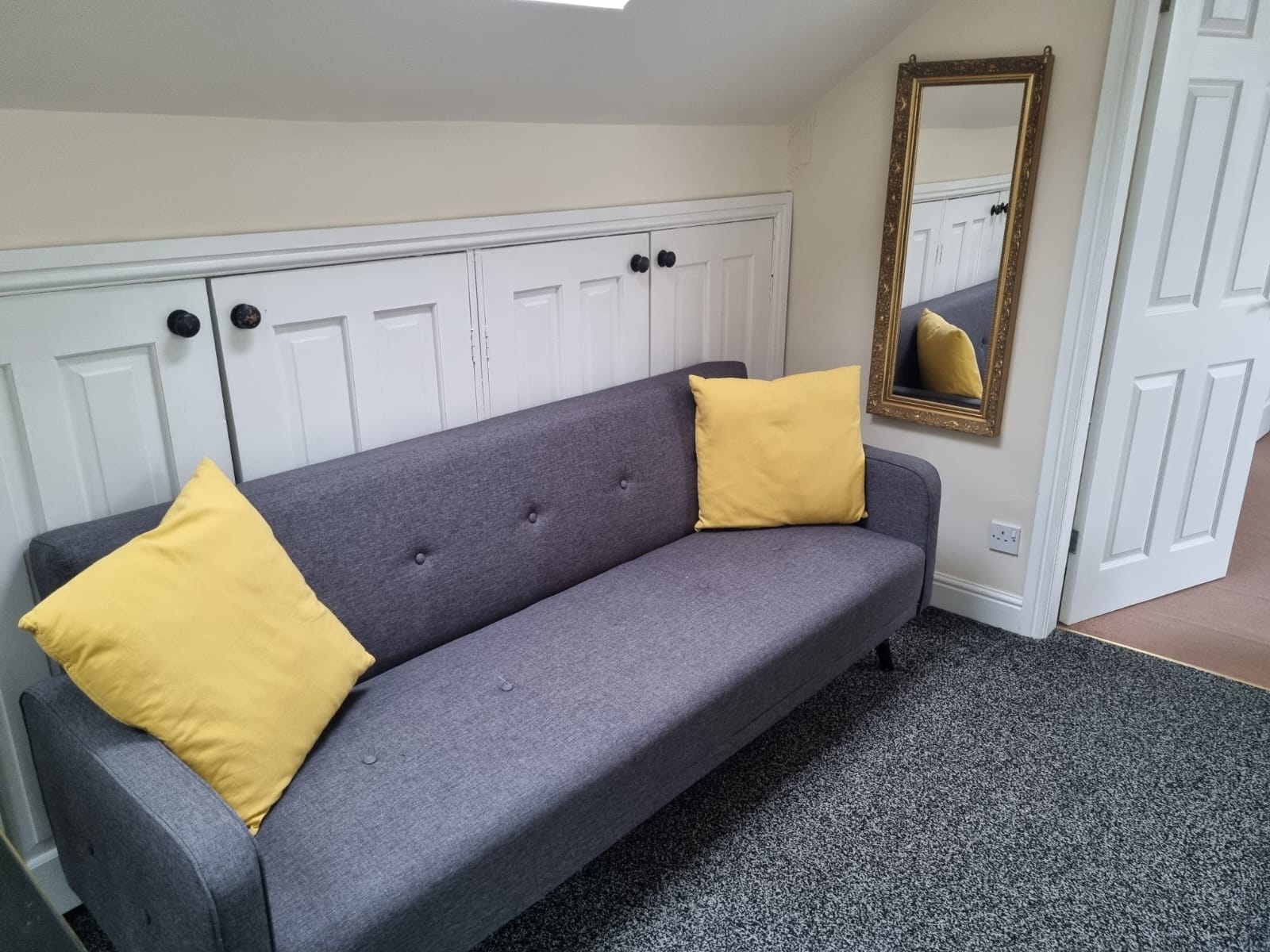 sofa in front of some wall cupboards in Granary cottage