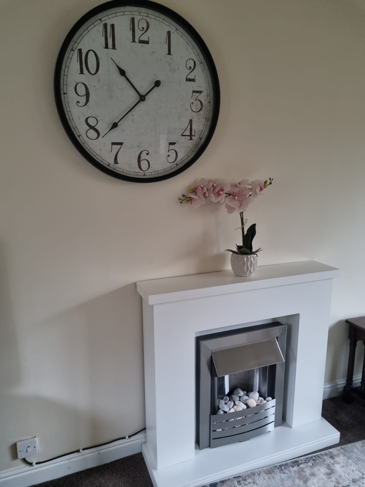 Fireplace with a clock above it in Granary cottage